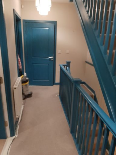 a photo of a blue door and salmon coloured doors. a workman can be seen with a vacuum cleaner after cleaning up